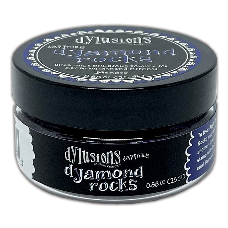 Sapphire (metallic mid to dark blue)  Dyamond Rocks ... Dylusions by Dyan Reaveley and Ranger Ink. Jar of Ultra Thick Embossing Powder used to create dimension and shaped layers with a smooth, 3-dimensional raised layer with an enamel-like finish. Use with junk journals, book covers, ornaments, decorations, off-the-page creativity, scrapbooks, greeting cards, mixed media, visual sculptured artwork and more. Photo of the jar.