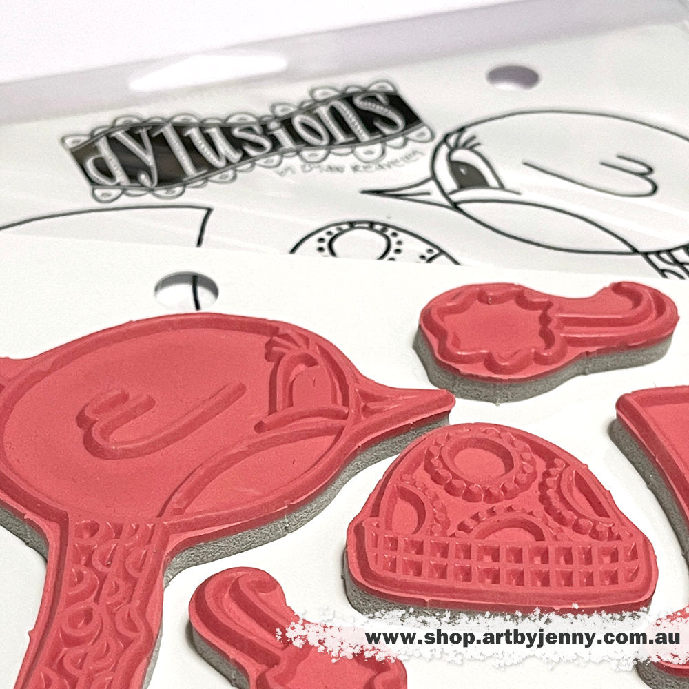 photograph of the Robin Couture Dylusions Stamp Set (DYR10009). Original designs by Dyan Reaveley, made by Stampers Anonymous out of red rubber mounted on cling foam. Perfect for mixed media, art journaling, scrapbooking, stamping on fabrics, using in papercrafts and visual arts of all kinds. 16 (sixteen) designs. These fun and whimsical designs include a pair of long legged feathered friends (birds) facing in opposite directions, plus a whole stash of their favourite fashion accessories to wear.