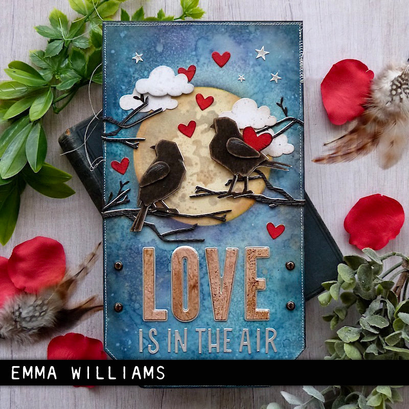 large art tag made by Emma Williams with words 'love is in the air'- using the from the Vault Thinlits Die Cutting Templates by Tim Holtz, made by Sizzix (no.666566). These designs cut out three bird silhouettes (garden variety, sparrows), a branch, feather and trio of hearts. Add these versatile designs to greeting cards, tags, off the page displays, cards, scrapbook pages, art journaling, all kinds of visual arts and papercrafts.