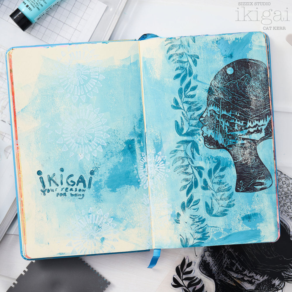 Ikigai - Stencils and Stamps ... Sizzix Studio Mixed Media Kit ... by Cat Kerr and Sizzix. Layering art stencils and clear acrylic stamps to use for mixed media, papercrafts, art journaling, visual arts of all kinds. Beautiful mountain and river scene within a face, flying flocks of birds, mandala patterns, leaves and more. Photo of wonderful example by Cat Kerr.