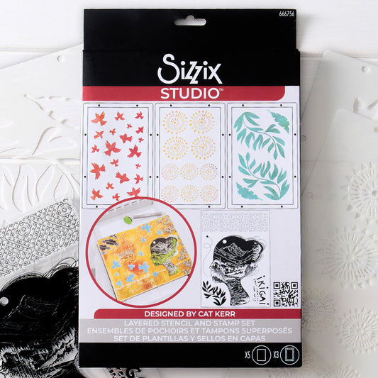 Ikigai - Stencils and Stamps ... Sizzix Studio Mixed Media Kit ... by Cat Kerr and Sizzix. Layering art stencils and clear acrylic stamps to use for mixed media, papercrafts, art journaling, visual arts of all kinds. Beautiful mountain and river scene within a face, flying flocks of birds, mandala patterns, leaves and more. Photograph of the packaging.