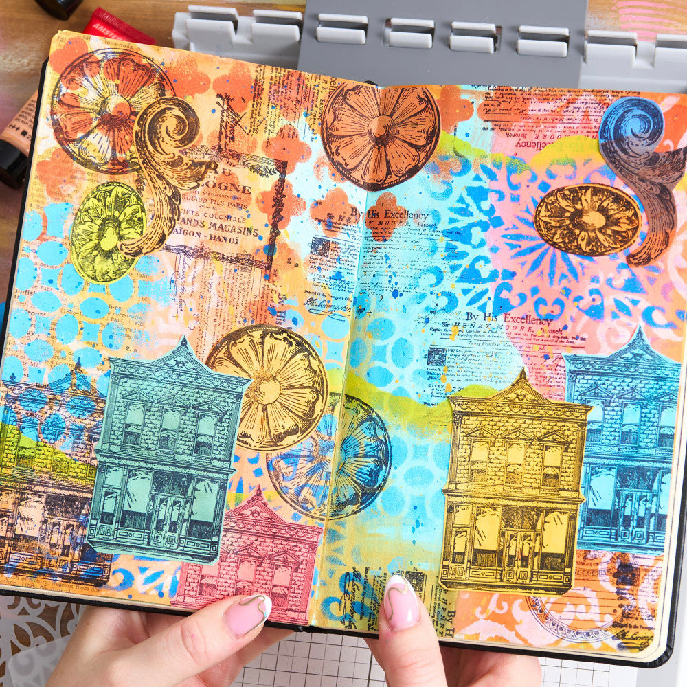 sample of Build It - Stencils and Stamps ... Sizzix Studio Mixed Media Kit ... by Mark Montano and Sizzix. Layering art stencils and clear acrylic stamps to use for mixed media, papercrafts, art journaling, visual arts of all kinds. Pack has 7 (seven) stamp designs and 3 (three) stencils, 6 3/4" x 10" in size.
The stamp designs in this set include a Royal notice, vintage round label, floral round and oval plaster cast, simple scroll, eau de cologne advert, double storey brick building with shopfront window