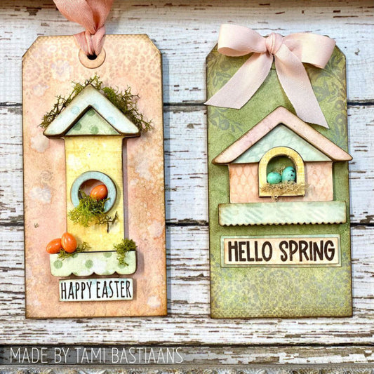 Birdhouse Ornaments - Thickboard Shapes by Stampers Anonymous. 2 (two) sheets of compressed board with precut designs of little bird house pieces, ready to pop out and use to create 4 (four) house faces, 2 short and 2 tall. 18 pieces per sheet. ORN01 Each sheet is 4 1/2" x 6 3/4" and approx 2mm thick. Photograph of birdhouse tags by Tami Bastiaans in peach and green for Easter and Spring.