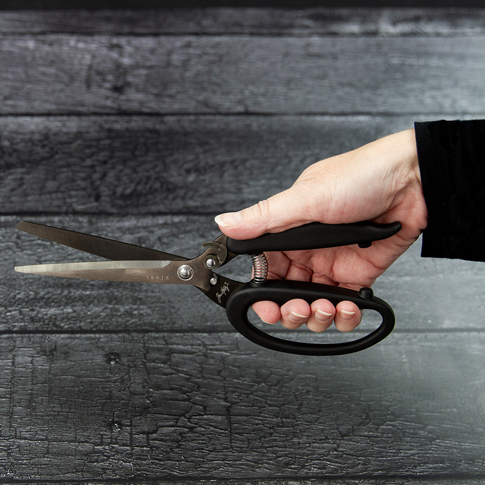 Recoil Snips, 9.5" Scissors - by Tim Holtz and Tonic Studios ... Titanium-coated, double-bevelled long, straight, smooth, strong and sharp blades with customisable spring tension to provide a smooth precise cutting experience for both left and right handed crafters. Image of an open pair of Tim Holtz Tonic Studios Recoil Scissors (9.5" shears) in a hand being used.