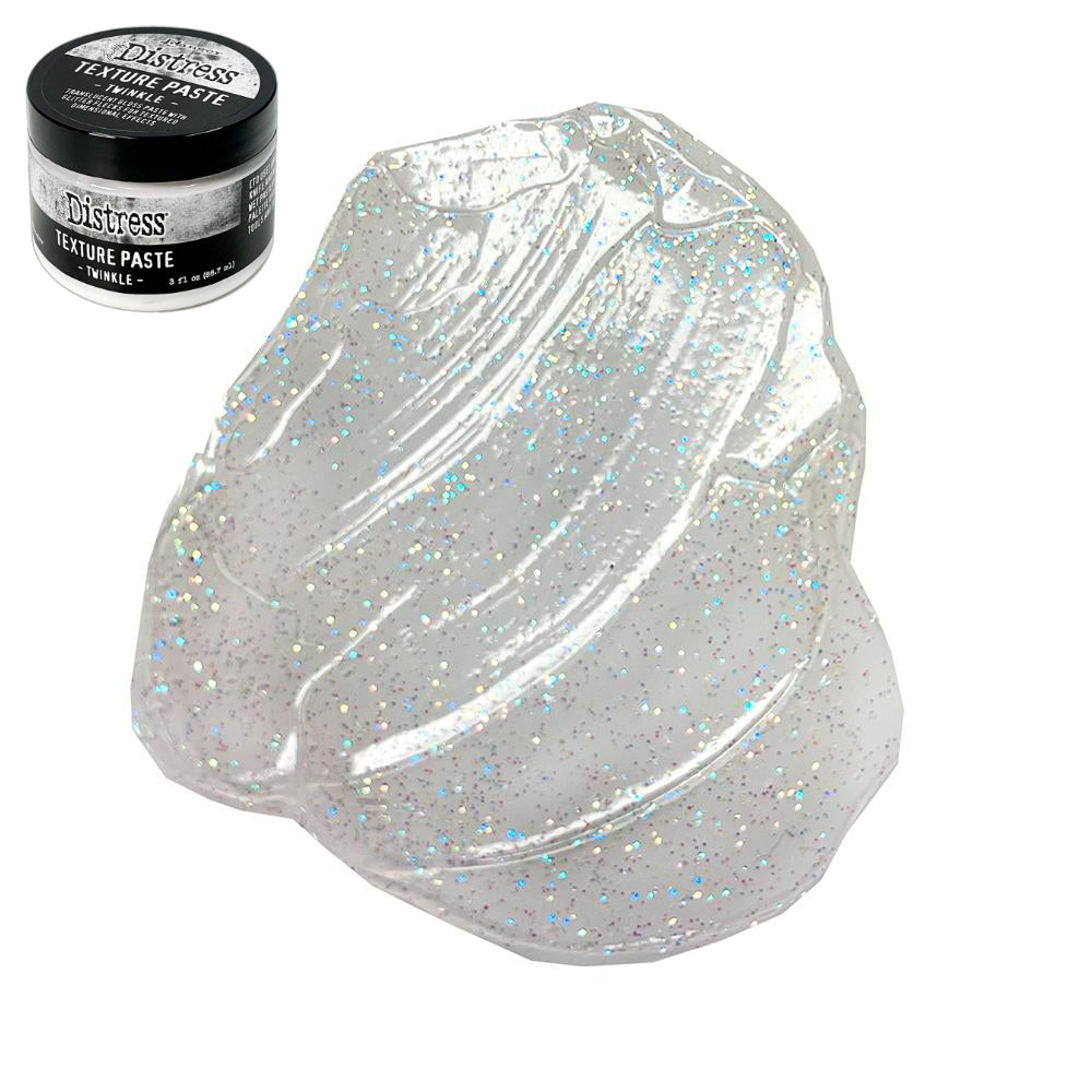 Twinkle - Texture Paste, Translucent, Shimmery and Shiny - Tim Holtz Distress dimensional medium with clear coverage, sparkly glittery highlights and gloss finish, 3fl oz (88.7ml) jar. Made by Ranger. Tim Holtz Distress® Texture Paste Twinkle is a translucent gloss paste with glitter flecks for dimensional effects. The gorgeous Distress Twinkle Texture Paste can be altered and stained to enable endless colourful possibilities for creativity. Photo on white.