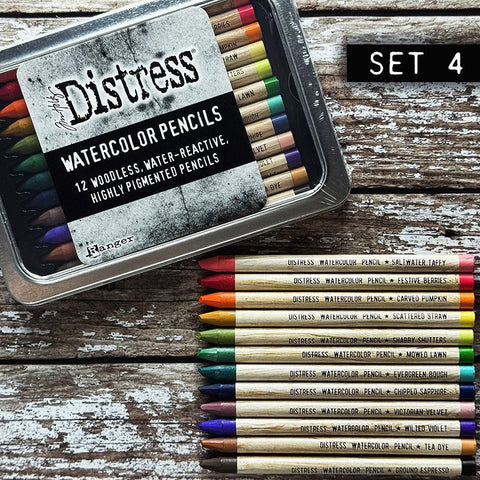 Woodless Watercolour Pencils in Distress colours, set 4 ... by Tim Holtz and Ranger. 12 (twelve) woodless watercolour pencils in Saltwater Taffy, Festive Berries, Carved Pumpkin, Scattered Straw, Shabby Shutters, Mowed Lawn, Evergreen Bough, Chipped Sapphire, Victorian Velvet, Wilted Violet, Tea Dye, Ground Espresso. One of each colour, approx 5" long. Photo showing a tin of pencils with 12 loose pencils.