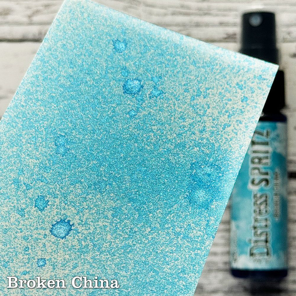 Broken China - Distress Spritz by Tim Holtz and Ranger - a pearlised fusion of colourful mica pigment and clear medium to easily create a gorgeous shimmery splattery effect on artwork in colours that compliment the whole Distress rainbow. Each bottle contains 1 fl oz (29ml) with a fine spritzing nozzle and easy to hold container. Use Tim Holtz Distress Spritz for mixed media, scrapbooking, paper crafts, card making, junk journals and visual arts. Photo is a sample by Ranger.