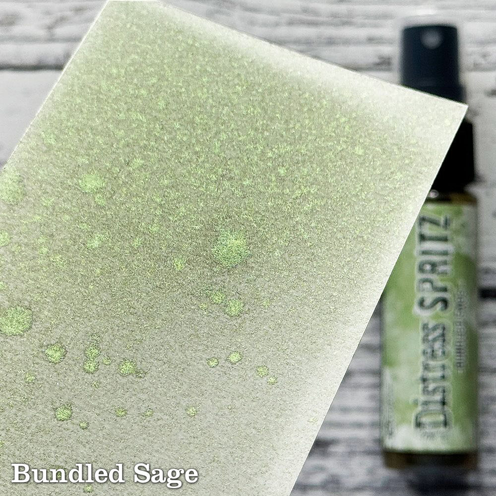 Bundled Sage - Distress Spritz by Tim Holtz and Ranger - a pearlised fusion of colourful mica pigment and clear medium to easily create a gorgeous shimmery splattery effect on artwork in colours that compliment the whole Distress rainbow. Each bottle contains 1 fl oz (29ml) with a fine spritzing nozzle and easy to hold container. Use Tim Holtz Distress Spritz for mixed media, scrapbooking, paper crafts, card making, junk journals and visual arts. Photo is a sample by Ranger.