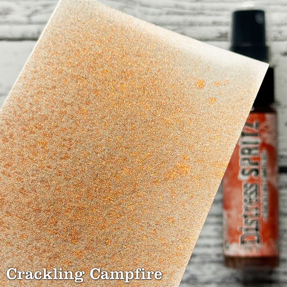 Crackling Campfire - Distress Spritz by Tim Holtz and Ranger - a pearlised fusion of colourful mica pigment and clear medium to easily create a gorgeous shimmery splattery effect on artwork in colours that compliment the whole Distress rainbow. Each bottle contains 1 fl oz (29ml) with a fine spritzing nozzle and easy to hold container. Use Tim Holtz Distress Spritz for mixed media, scrapbooking, paper crafts, card making, junk journals and visual arts. Photo is a sample by Ranger.