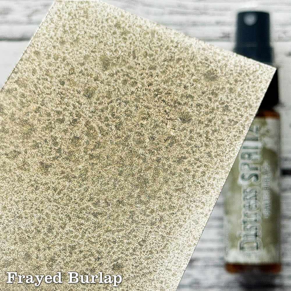 Frayed Burlap - Distress Spritz by Tim Holtz and Ranger - a pearlised fusion of colourful mica pigment and clear medium to easily create a gorgeous shimmery splattery effect on artwork in colours that compliment the whole Distress rainbow. Each bottle contains 1 fl oz (29ml) with a fine spritzing nozzle and easy to hold container. Use Tim Holtz Distress Spritz for mixed media, scrapbooking, paper crafts, card making, junk journals and visual arts. Photo is a sample by Ranger.