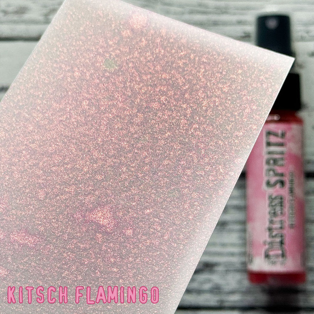 Kitsch Flamingo - Distress Spritz by Tim Holtz and Ranger - a pearlised fusion of colourful mica pigment and clear medium to easily create a gorgeous shimmery splattery effect on artwork in colours that compliment the whole Distress rainbow. Each bottle contains 1 fl oz (29ml) with a fine spritzing nozzle and easy to hold container. Use Tim Holtz Distress Spritz for mixed media, scrapbooking, papercrafts, cardmaking, junk journals and visual arts. Photo is a sample by Ranger.
