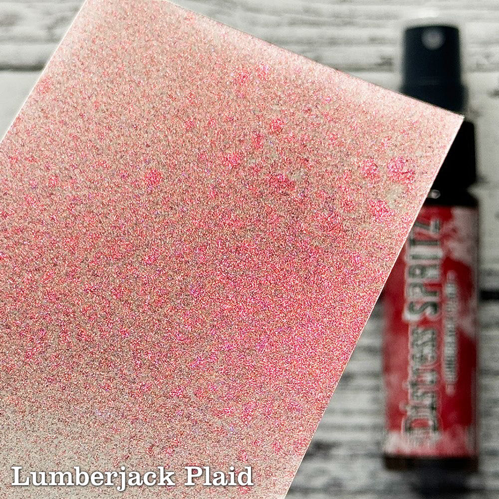 Lumberjack Plaid - Distress Spritz by Tim Holtz and Ranger - a pearlised fusion of colourful mica pigment and clear medium to easily create a gorgeous shimmery splattery effect on artwork in colours that compliment the whole Distress rainbow. Each bottle contains 1 fl oz (29ml) with a fine spritzing nozzle and easy to hold container. Use Tim Holtz Distress Spritz for mixed media, scrapbooking, paper crafts, card making, junk journals and visual arts. Photo is a sample by Ranger.