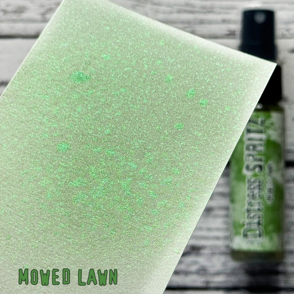 Mowed Lawn - Distress Spritz by Tim Holtz and Ranger - a pearlised fusion of colourful mica pigment and clear medium to easily create a gorgeous shimmery splattery effect on artwork in colours that compliment the whole Distress rainbow. Each bottle contains 1 fl oz (29ml) with a fine spritzing nozzle and easy to hold container. Use Tim Holtz Distress Spritz for mixed media, scrapbooking, papercrafts, cardmaking, junk journals and visual arts. Photo is a sample by Ranger.