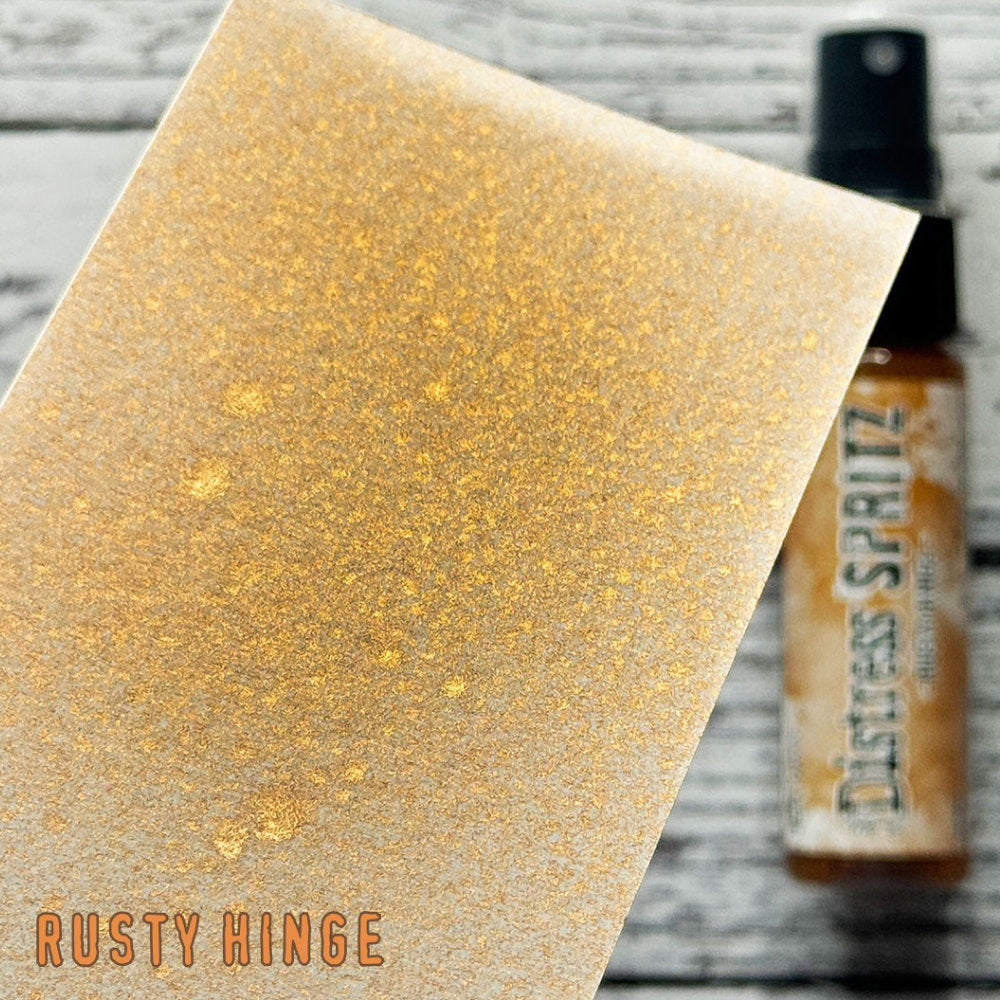 Rusty Hinge - Distress Spritz by Tim Holtz and Ranger - a pearlised fusion of colourful mica pigment and clear medium to easily create a gorgeous shimmery splattery effect on artwork in colours that compliment the whole Distress rainbow. Each bottle contains 1 fl oz (29ml) with a fine spritzing nozzle and easy to hold container. Use Tim Holtz Distress Spritz for mixed media, scrapbooking, papercrafts, cardmaking, junk journals and visual arts. Photo is a sample by Ranger.