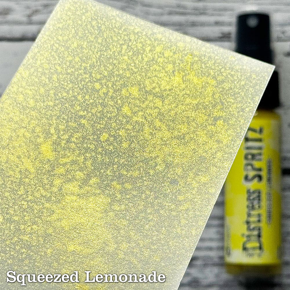 Squeezed Lemonade - Distress Spritz by Tim Holtz and Ranger - a pearlised fusion of colourful mica pigment and clear medium to easily create a gorgeous shimmery splattery effect on artwork in colours that compliment the whole Distress rainbow. Each bottle contains 1 fl oz (29ml) with a fine spritzing nozzle and easy to hold container. Use Tim Holtz Distress Spritz for mixed media, scrapbooking, paper crafts, card making, junk journals and visual arts. Photo is a sample by Ranger.