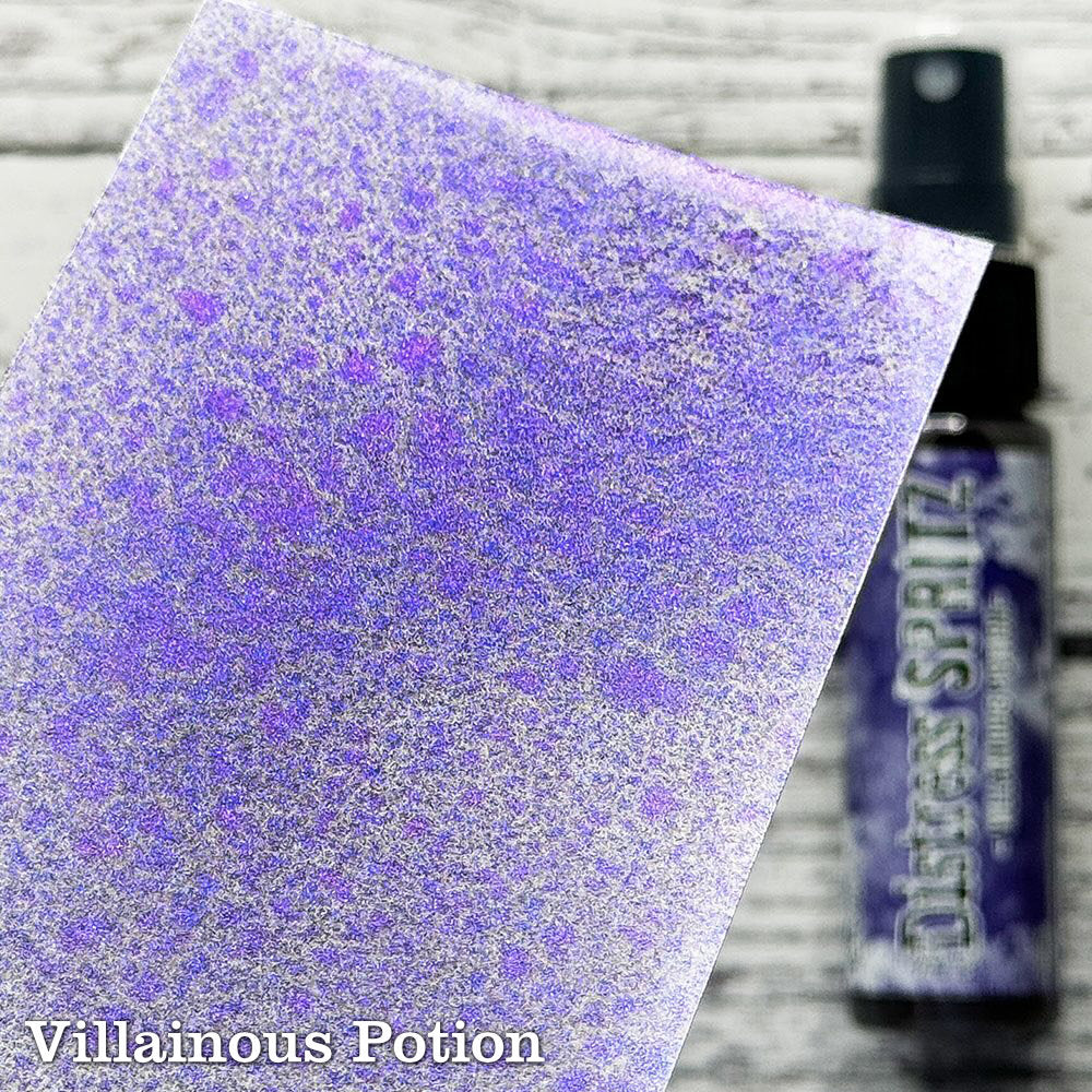 Villainous Potion (purple) - Distress Spritz by Tim Holtz and Ranger - a pearlised fusion of colourful mica pigment and clear medium to easily create a gorgeous shimmery splattery effect on artwork in colours that compliment the whole Distress rainbow. Each bottle contains 1 fl oz (29ml) with a fine spritzing nozzle and easy to hold container. Use Tim Holtz Distress Spritz for mixed media, scrapbooking, paper crafts, card making, junk journals and visual arts. Photo is a sample by Ranger.
