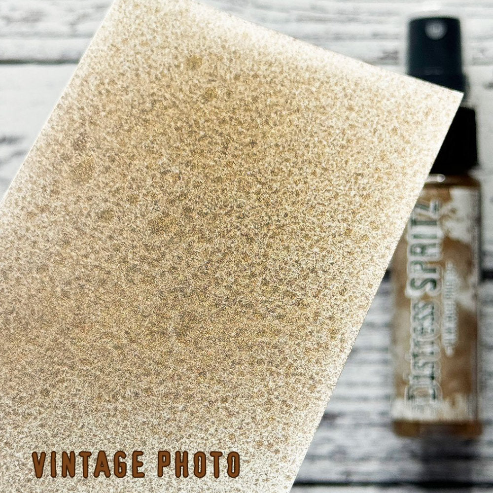 Vintage Photo - Distress Spritz by Tim Holtz and Ranger - a pearlised fusion of colourful mica pigment and clear medium to easily create a gorgeous shimmery splattery effect on artwork in colours that compliment the whole Distress rainbow. Each bottle contains 1 fl oz (29ml) with a fine spritzing nozzle and easy to hold container. Use Tim Holtz Distress Spritz for mixed media, scrapbooking, papercrafts, cardmaking, junk journals and visual arts. Photo is a sample by Ranger.
