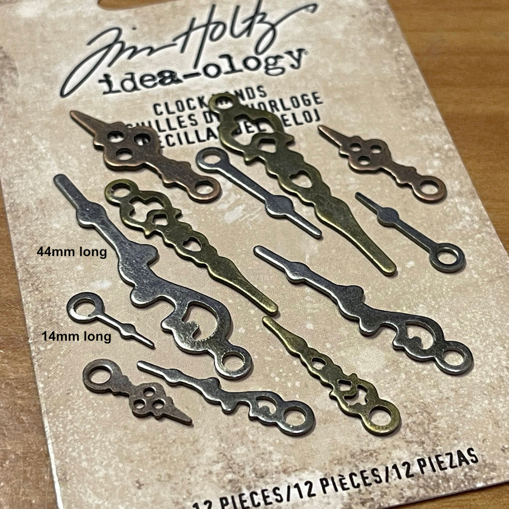 close up photograph of Clock Hands ... Idea-Ology Adornments by Tim Holtz. A collection of delicate vintage miniature metal clock hands in antique colours to use for mixed media, decorating ornaments, home decor makes and visual arts. 12 (twelve) pieces in various sizes (14mm to 44mm long). TH93693