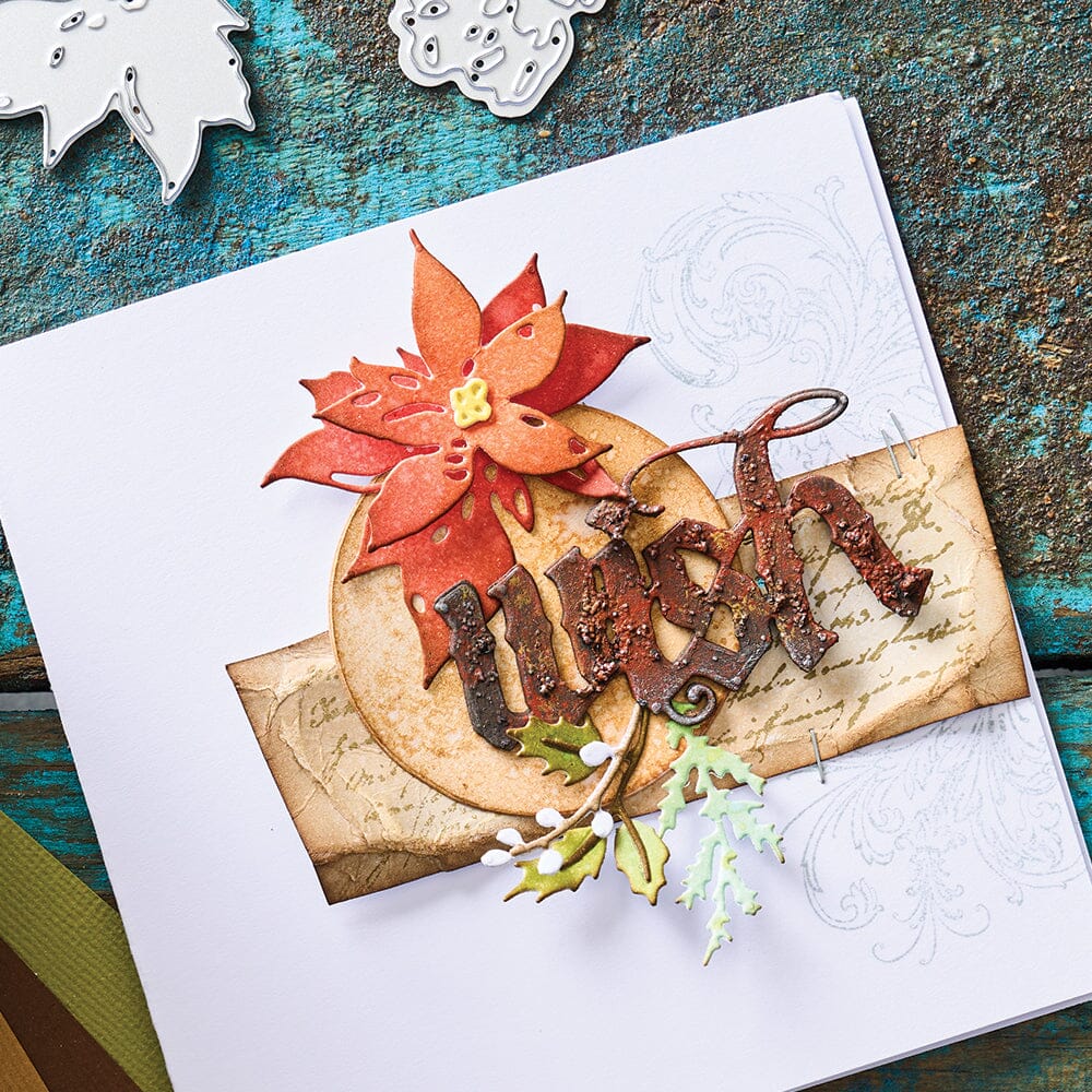Holiday Classic - from the Vault ... Thinlits Die Cutting Templates by Tim Holtz, made by Sizzix (no.666716). These designs cut out three festive words (wish, peace, noel) in beautiful olde worlde typeface, plus a bell, poinsettias, foliage and pinecone. Photo showing a greeting card made using a white base, red poinsettia flower over a circle and the word wish with foliage.