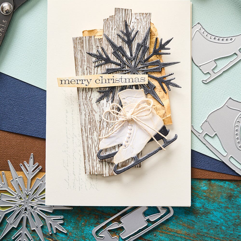 Winter Wishes - from the Vault ... Thinlits Die Cutting Templates by Tim Holtz, made by Sizzix (no.666717). These designs cut out a little snowman with scarf, arms, hat and carrot nose, plus a beautiful snowflake and a detailed pair of vintage ice skates. Photograph of a Christmas card featuring timber pieces, large snowflake and vintage skates with 'merry Christmas'.