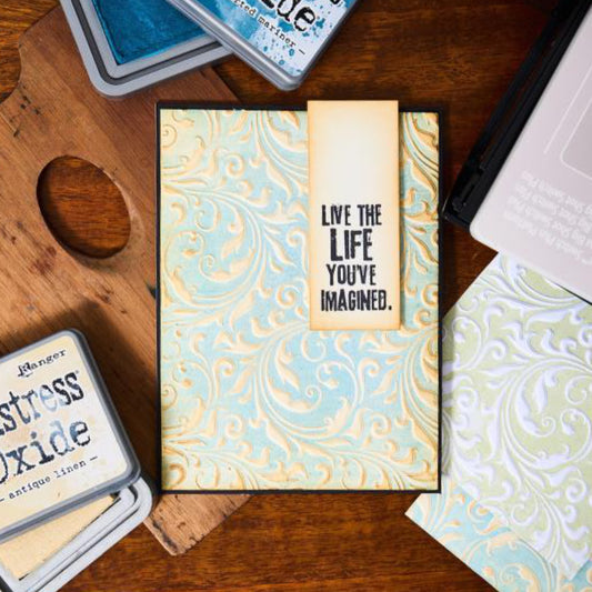 Flourish - Texture Fades Embossing Folder ... by Tim Holtz and Sizzix (no.666868).
Inspired by beautiful nostalgic patterns, this easy to use embossing folder creates a wonderfully flowing flourish pattern with paper, vellum and cardstock. The detailed design and linework create amazing multi layered dimensional texture, ideal for all kinds of papercrafts, pockets, junk journals, scrapbook pages, card backgrounds, anything you wish to make! Photo of a card made using this design.