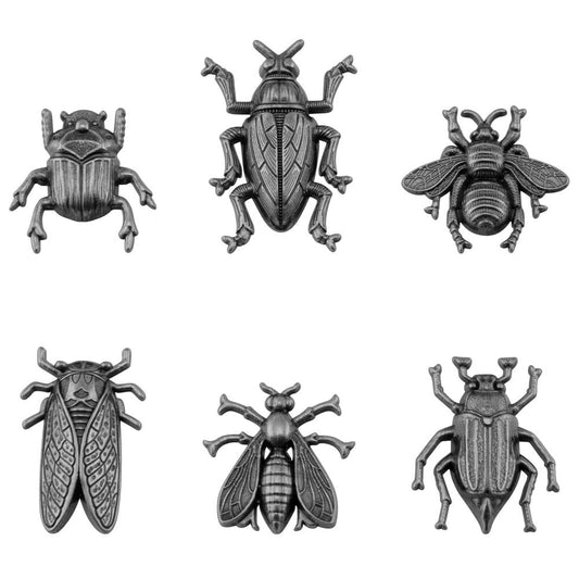 Entomology - Idea-Ology Adornments - by Tim Holtz - 6 (six) silver coloured metal embellishments to use in papercrafts, jewellery making and visual arts. 1 of each design.  Metal Adornments 'Entomology' is a collection of flying insects - 1 scarab, 1 cicada, 1 bee, 1 wasp and 2 beetles. Each insect has amazing detail in their bodies, feet, antennae and wings. Designed to sit flat on the page with a hollow underside to help them sit flat on your page.