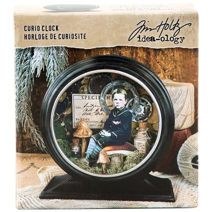 Curio Clock Frame, Matte Black ... by Tim Holtz Idea-Ology - Use for mixed media, assemblage projects, off-the-page marvels and party decor. Pack of 1 (one) metal round frame with rectangle base (an empty clock frame) with silver surround. , image of the packaging with an example of use
