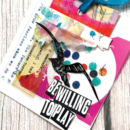 Sample made by Dina Wakley, the artist behind 'Dina Wakley MEdia' visual arts designer and creator. Artwork features flying bird, quote (be willing to play), tissue layers, transparent abstract prints, in colours of white, vintage tea stain, blue ribbon, red, bright pink and black.