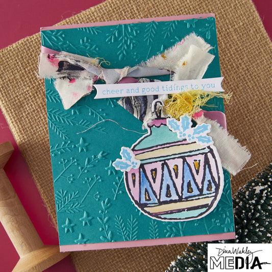 Wonderful Christmas Card made by Dina Wakley using Spellbinder Paper Arts BetterPress Plates and Embossing Folder . Use the designs in mixed media, cardmaking, journaling, scrapbooking and visual arts. Dina's Spellbinders sets include festive designs of birds, baubles, heartfelt messages, holly and berries, spots, crescent moon, reindeer, foliage and stars. All the DWM metal embossing and printing plates can to be used together or separately to create dimension with or without ink. Enjoy!