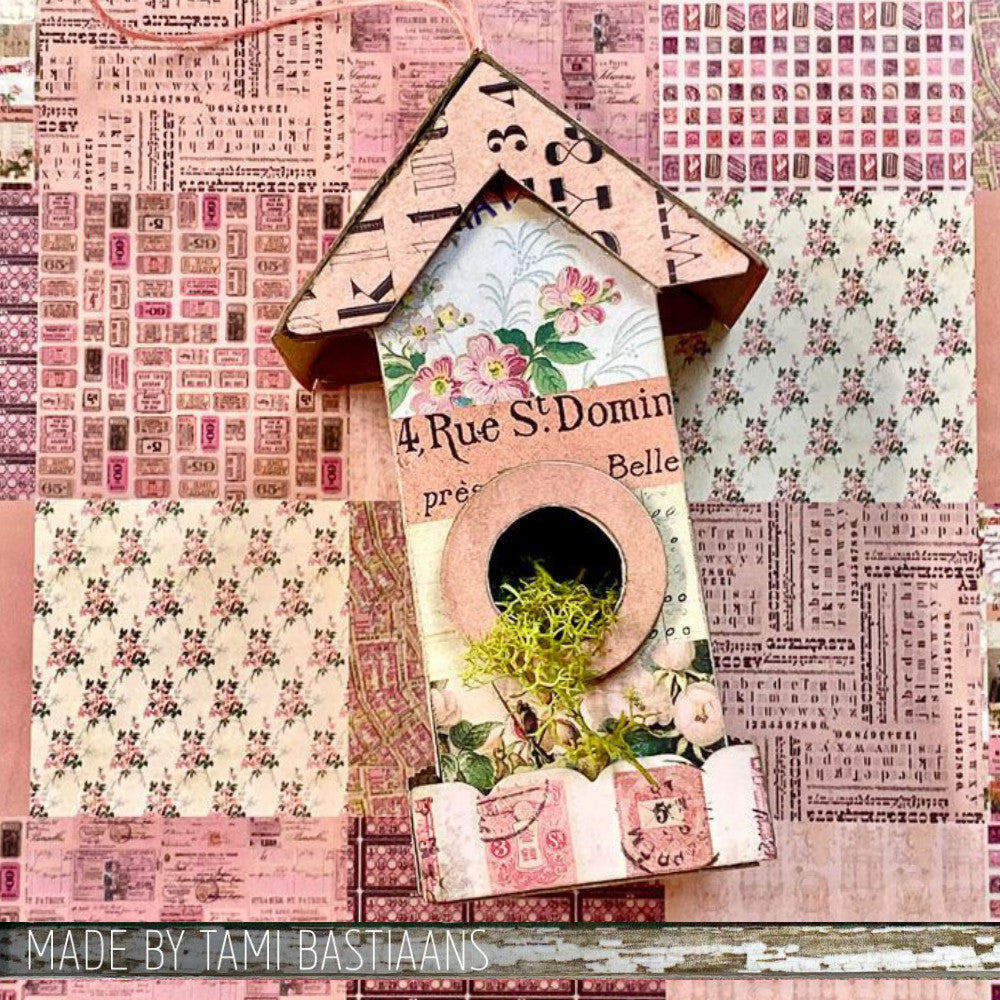 Birdhouse Ornaments - Thickboard Shapes by Stampers Anonymous. 2 (two) sheets of compressed board with precut designs of little bird house pieces, ready to pop out and use to create 4 (four) house faces, 2 short and 2 tall. 18 pieces per sheet. ORN01  Each sheet is 4 1/2" x 6 3/4" and approx 2mm thick. Photograph of a birdhouse by Tami Bastiaans, made using the Tim Holtz Idea-Ology Palette Paper in Pink.