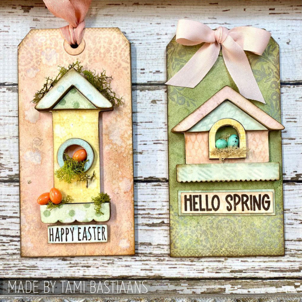 Birdhouse Ornaments - Thickboard Shapes by Stampers Anonymous. 2 (two) sheets of compressed board with precut designs of little bird house pieces, ready to pop out and use to create 4 (four) house faces, 2 short and 2 tall. 18 pieces per sheet. ORN01  Each sheet is 4 1/2" x 6 3/4" and approx 2mm thick. Photograph of birdhouse tags by Tami Bastiaans in peach and green for Easter and Spring.