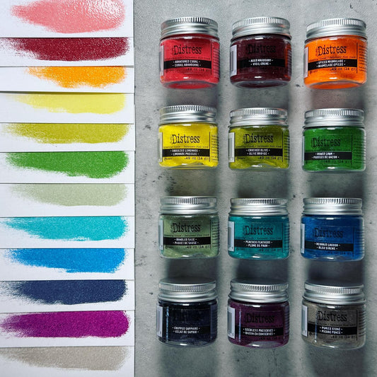 Distress Embossing Glaze by Tim Holtz and Ranger. Distress Embossing Glaze is a fine embossing powder that once melted with a heat tool, creates a colourful tinted semi translucent and slightly textured glazing effect (like a varnish or enamel). Ideal for lettering, stamped images, stenciled areas, abstracts, backgrounds, cardmaking, mixed media, visual arts. Layer over other Distress inks, paints and stains for an unlimited colour palette. Photo by Tim of 12 colours released July 2023