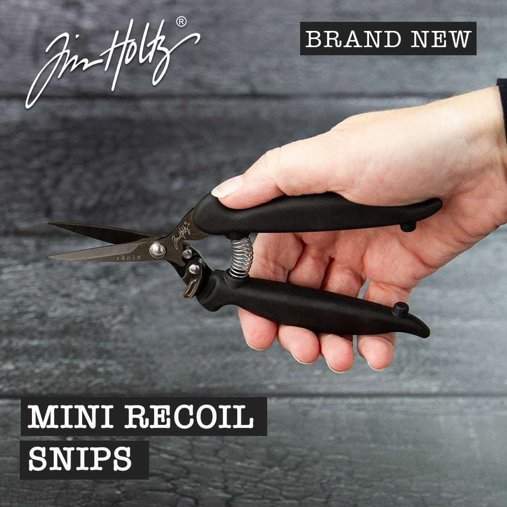 Recoil Snips, 7" Scissors - by Tim Holtz and Tonic Studios ... Titanium-coated, double-bevelled smooth sharp blades with customisable spring tension to provide a smooth precise cutting experience for both left and right handed crafters. A fusion of ingenuity plus innovation, Tim Holtz Recoil Scissors have features specifically designed for the maker (creators, crafters, artists). Image of an open pair of Tim Holtz Tonic Studios Recoil Snips (7" scissors) in a hand.