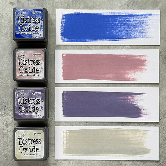 Mini Distress Oxide Ink Pads - Set 11 - by Tim Holtz and Ranger ... featuring water-reactive dye and pigment ink fusion that creates an oxidised effect when spattered, stamped, brushed and or sprayed with water. The colours are opaque and dry with a soft matte finish. Set of 4 (four) colours in Mini Ink Pad Cubes with 1" square raised felt, one of each (TDIK91578).

Colours in this set are ...
- Blueprint Sketch
- Victorian Velvet
- Dusty Concord
- Old Paper
... one of each colour. Photographic example.
