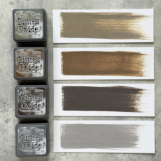 Mini Distress Oxide Ink Pads - Set 12 - by Tim Holtz and Ranger ... featuring water-reactive dye and pigment ink fusion that creates an oxidised effect when spattered, stamped, brushed and or sprayed with water. The colours are opaque and dry with a soft matte finish. Set of 4 (four) colours in Mini Ink Pad Cubes with 1" square raised felt, one of each (TDIK91585).

Colours in this set are ...
- Frayed Burlap
- Gathered Twigs
- Ground Espresso
- Hickory Smoke
... one of each colour. Photo example.