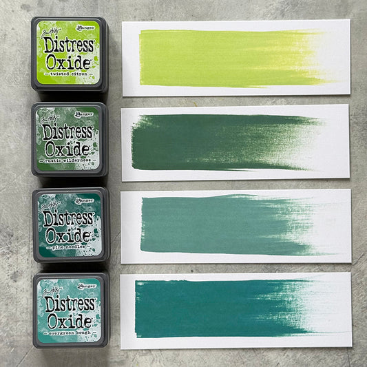 Mini Distress Oxide Ink Pads - Set 9 - by Tim Holtz and Ranger ... featuring water-reactive dye and pigment ink fusion that creates an oxidised effect when spattered, stamped, brushed and or sprayed with water. The colours are opaque and dry with a soft matte finish. Set of 4 (four) colours in Mini Ink Pad Cubes with 1" square raised felt, one of each (TDIK91554).

Colours in this set are ...
- Twisted Citron
- Rustic Wilderness
- Evergreen Bough
- Pine Needles
... one of each colour. Photographic example