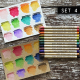 Woodless Watercolour Pencils in Distress colours, set 4 ... by Tim Holtz and Ranger. 12 (twelve) woodless watercolour pencils in Saltwater Taffy, Festive Berries, Carved Pumpkin, Scattered Straw, Shabby Shutters, Mowed Lawn, Evergreen Bough, Chipped Sapphire, Victorian Velvet, Wilted Violet, Tea Dye, Ground Espresso. One of each colour, approx 5" long. Photo of Tim Holtz's swatches with the 12 pencils.