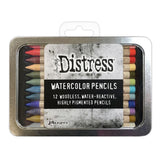 Woodless Watercolour Pencils in Distress colours, set 6 ... by Tim Holtz and Ranger. 12 (twelve) woodless watercolour pencils in Spun Sugar, Abandoned Coral, Lumberjack Plaid, Dried Marigold, Forest Moss, Bundled Sage, Broken China, Stormy Sky, Blueprint Sketch, Dusty Concord, Brushed Corduroy, Lost Shadow. One of each colour, approx 5" long. Photo of a closed tin with a label.