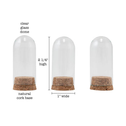 Glass Display Domes, Mini, with Cork Bases ... by Tim Holtz Idea-Ology - Use for mixed media, assemblage projects, off-the-page marvels and party decor. Pack of 3 (three) tall narrow glass displays with domed shape and natural cork bases. Size is 25mm x 50mm tall, plus the height of the corks. Add to your project, off-the-page marvel, canvas or other artistic creation and attach using trimmings, fasteners or collage medium. Alter using alcohol inks, texture pastes, Distress crayons or Distress paints.