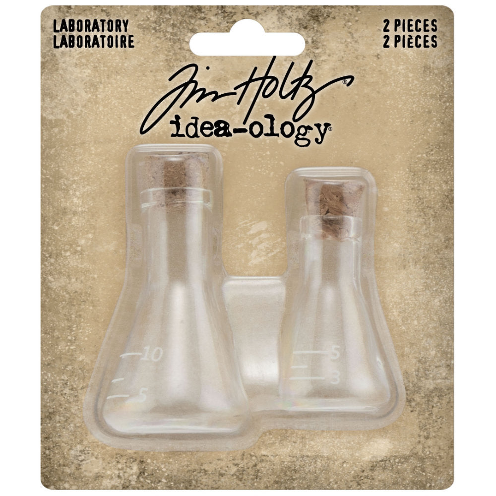 Laboratory Glass Flasks with Corks ... by Tim Holtz Idea-Ology - Use for mixed media, assemblage projects, off-the-page marvels and party decor. Pack of 2 (two) triangular shaped glass bottles with cork lids. Sizes are 24mm x 42mm tall and 30mm x 54mm tall, plus the height of the little corks. One of each size. Add to your project, off-the-page marvel, canvas or other artistic creation and attach using trimmings, fasteners or collage medium. TH94144