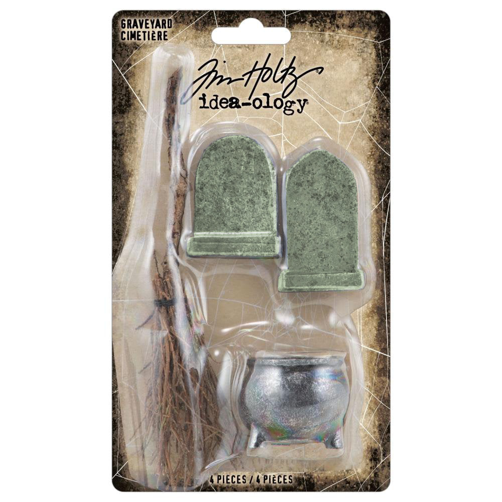 Graveyard - Cauldron, Broomstick and Headstones ... by Tim Holtz Idea-Ology - miniature models of Halloween essentials, moulded from durable resin and twigs. Use for mixed media, assemblage projects, off-the-page marvels and party decor. Pack of 4 (four) pieces, one of each. TH94337. Photo showing packaging