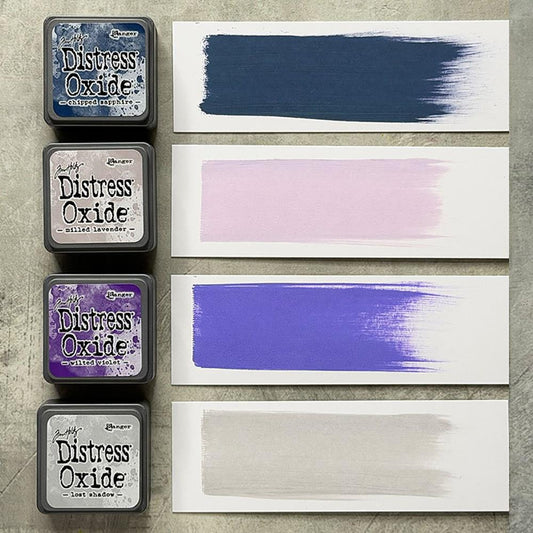 Mini Distress Oxide Ink Pads - Set 17 - by Tim Holtz and Ranger ... featuring water-reactive dye and pigment ink fusion that creates an oxidised effect when spattered, stamped, brushed and or sprayed with water. The colours are opaque and dry with a soft matte finish. Set of 4 (four) colours in Mini Ink Pad Cubes with 1" square raised felt, one of each (TDIK91639).

Colours in this set are ...
- Chipped Sapphire
- Milled Lavender
- Wilted Violet
- Lost Shadow
... one of each colour.