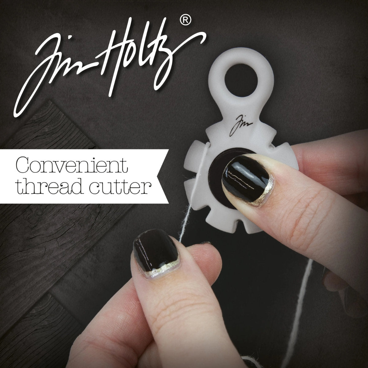 Paper Distresser - by Tim Holtz and Tonic Studios ... this is a tool for roughing up paper, cardstock edges and cutting threads in papercrafts, mixed media and tactile crafts. Includes a Kushgrip holder, hanging loop and 7 sharp recessed edges. Ergonomic Kushgrip round centre spot for comfort during handling, with very sharp steel blades recessed within the grey round plastic surround. It is safe to hold and easy to use. Photo from Tonic Studios of tool in use.