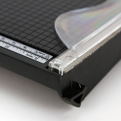 close up photograph of the gridded base, ruler, guide and deckle blade - Tim Holtz Deckle (Torn Edge) Blade Guillotine Paper Cutter - with a unique torn edge style blade, ergonomic comfort Kushgrip handle. Use to create the look of rugged torn edges to paper and cardboard easily and quickly. Made by Tonic Studio with precision ground, ultra sharp blade with a rough ragged pattern, this strong trimmer is built to last.
