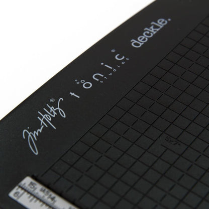 close up photo of the base platform with grid - Tim Holtz Deckle (Torn Edge) Blade Guillotine Paper Cutter - with a unique torn edge style blade, ergonomic comfort Kushgrip handle. Use to create the look of rugged torn edges to paper and cardboard easily and quickly. Made by Tonic Studio with precision ground, ultra sharp blade with a rough ragged pattern, this strong trimmer is built to last.