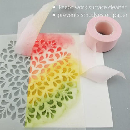 Pixie Tape Removable Adhesive - by iCraft, Thermoweb - 25mm (1") wide semi translucent with a pink tint, temporary masking or painter's tape. The photo is showing how to use with stencils, masking off areas and holding the stencil still while blending ink, paint or paste. The tape peels off easily without leaving tacky residue.