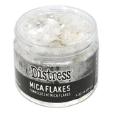 Mica Flakes ... by Tim Holtz Distress - translucent (clear) white pearl mica flakes, 1.3 oz (37 gram) wide opening jar. This jar of shimmery Mica Flakes is beautiful to look at, easy to work with and simple to clean up. These beautiful clear and clean Distress Mica Flakes are soft and light.