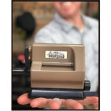 Tim Holtz Sidekick by Sizzix, portable black die cutting and embossing machine, photo shows Tim holding the original brown (retired) Sidekick to show how light and portable it is.