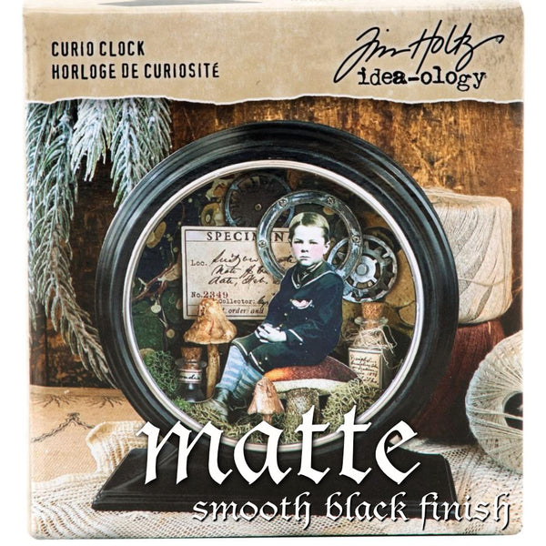 Curio Clock Frame, Matte Black ... by Tim Holtz Idea-Ology - Use for mixed media, assemblage projects, off-the-page marvels and party decor. 1 (one) open fronted, metal round frame with rectangle base and silver surround on the front. The frame is black inside and out, with a matte non-shiny finish.  Create your own unique miniature home, garden, scene or other amazing display piece using this black metal clock shaped frame. Photo of an example of use on the packaging.