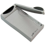 Mini Trimmer Guillotine by Tonic Studios and Tim Holtz - image showing an angled view of the portable cutting tool with the blade open, full view of the marked grid, safety guard and handle or storage pocket